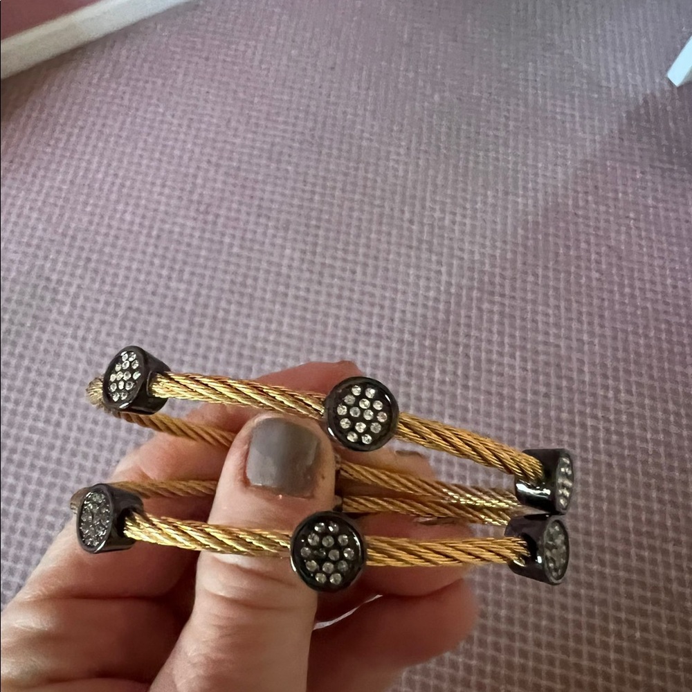 Yellow metal braided bracelets with alternating black circular charms